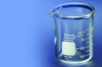 A glass beaker with a white label on it.